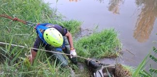 I volontari di Protezione civile rimuovono un ciclomotore dalla sponda del fiume Marecchia